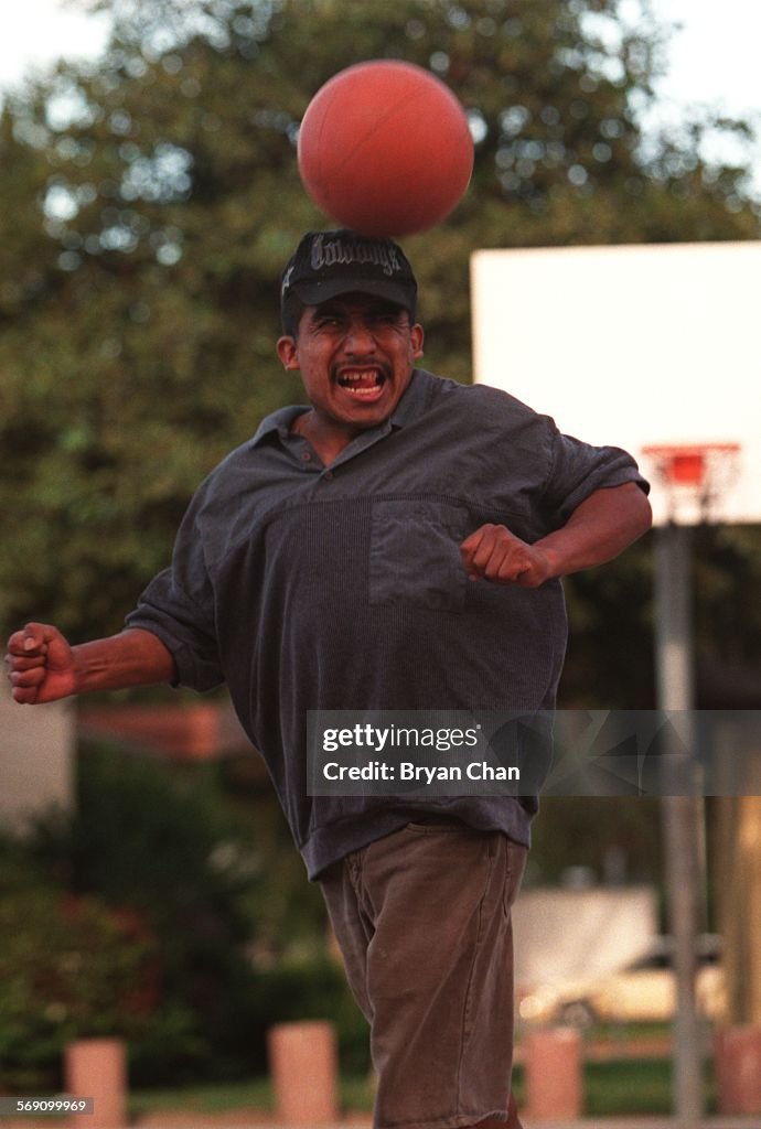 Michael Guzman crosses basketball with soccer by trying to make a basket using only his hands and fe