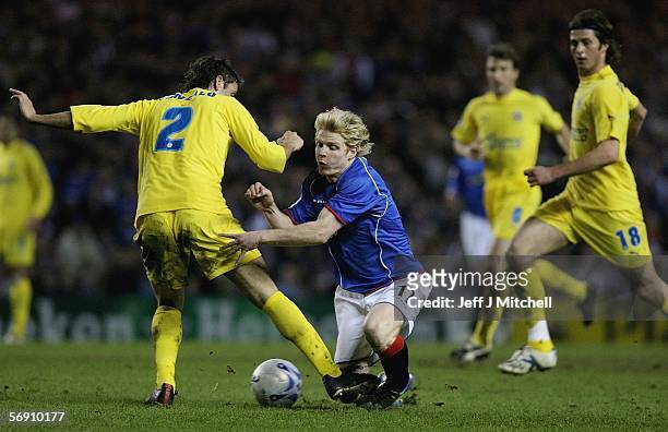 Chris Burke of Rangers is tackled by Gonzalo of Villarreal during the UEFA Champions League match between Rangers and Villarreal at Ibrox Stadium on...