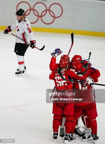 Members of team Russia celebrate Alexei Kovalev's third period goal to take a 2-0 lead over Canada as Wade Redden of Canada skates by during the...