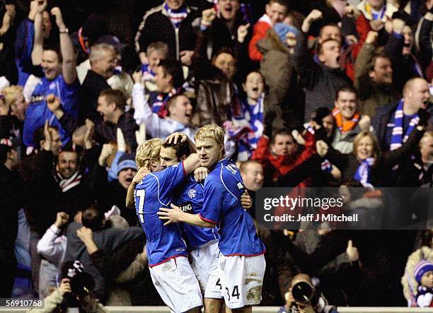 Chris Burke , Thomas Buffel and Steven Smith of Rangers celebrate the second goal during the UEFA Champions League match between Rangers and...
