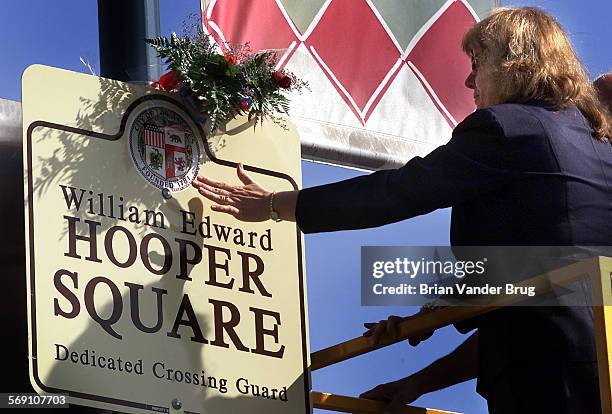 Carol Armstrong, right, fiance of slain crossing guard William Hooper, reaches out to touch memorial plaque at intersection of Bakman Ave. And...