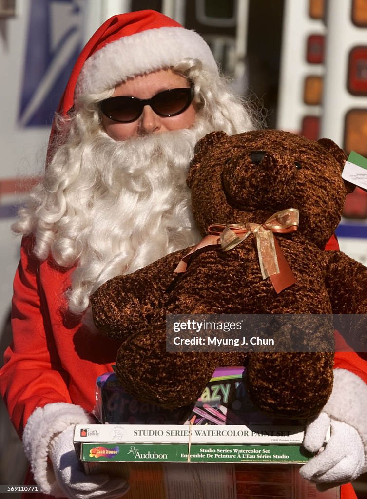 Postal employee Cindy Pritchard of the Woodland Hills office helps unload toys at the North Hollywoo