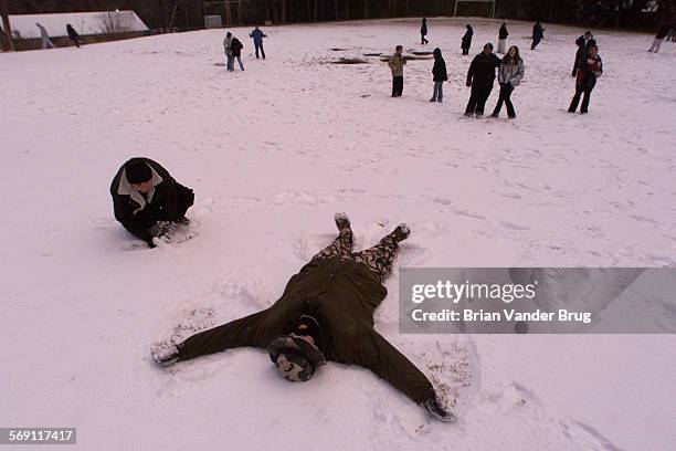 Hoover HS freshman Cody Abrahamson makes a snow angel in fresh fallen snow at Camp Cedar Falls in Angelus Oaks Wednesday February 7 2001during...