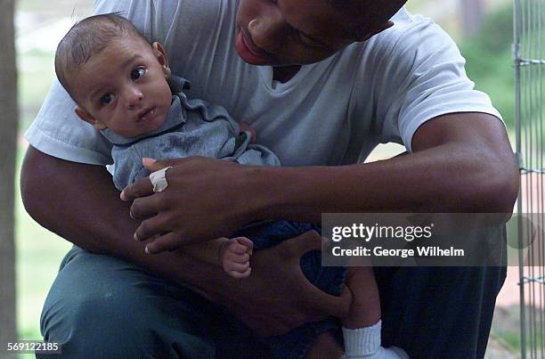 Month old boy named Isaiah is held gently by his father, a teen dad who is incarcerated at a juvinile probation camp near Malibu. Besides being...