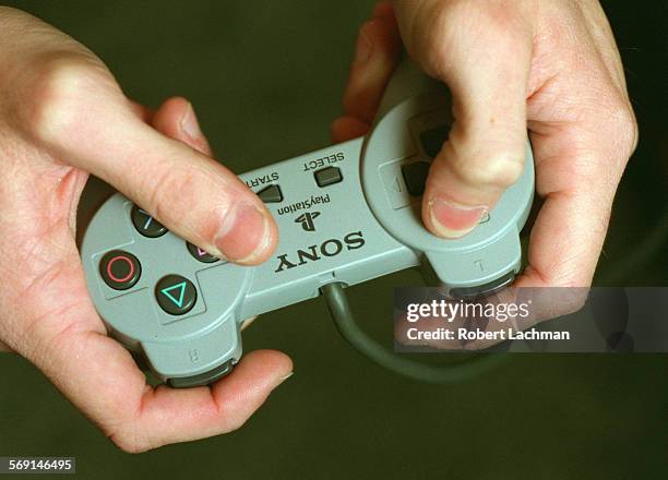 Tester/Hands.RDL A closeup of the hands of Aaron Lenz, lead product analyst for Virgin Interactive Entertainment with a Sony PlayStation control...