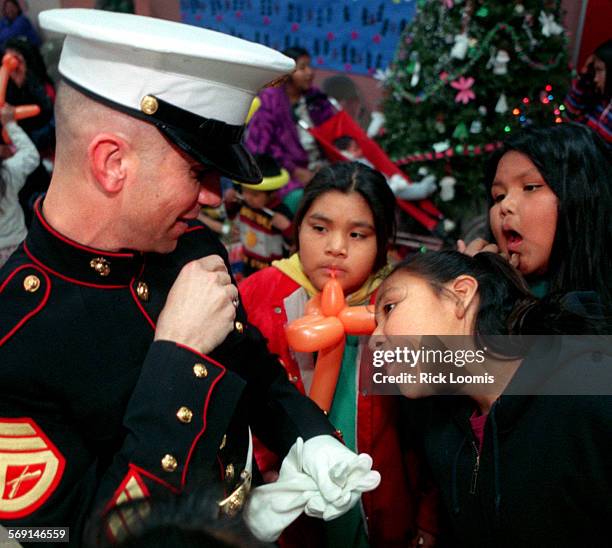 Toysfortots#2.1220.RLSupai, Az. Staff Sgt. Luis Torres, based in Yuma, Az., entertains Havasupai Indian children on their remote Grand Canyon...