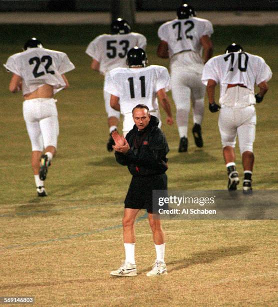 Chapman University head football coach Ken Visser cheers his team on during practice Wednesday evening at the Chapman University football field in...