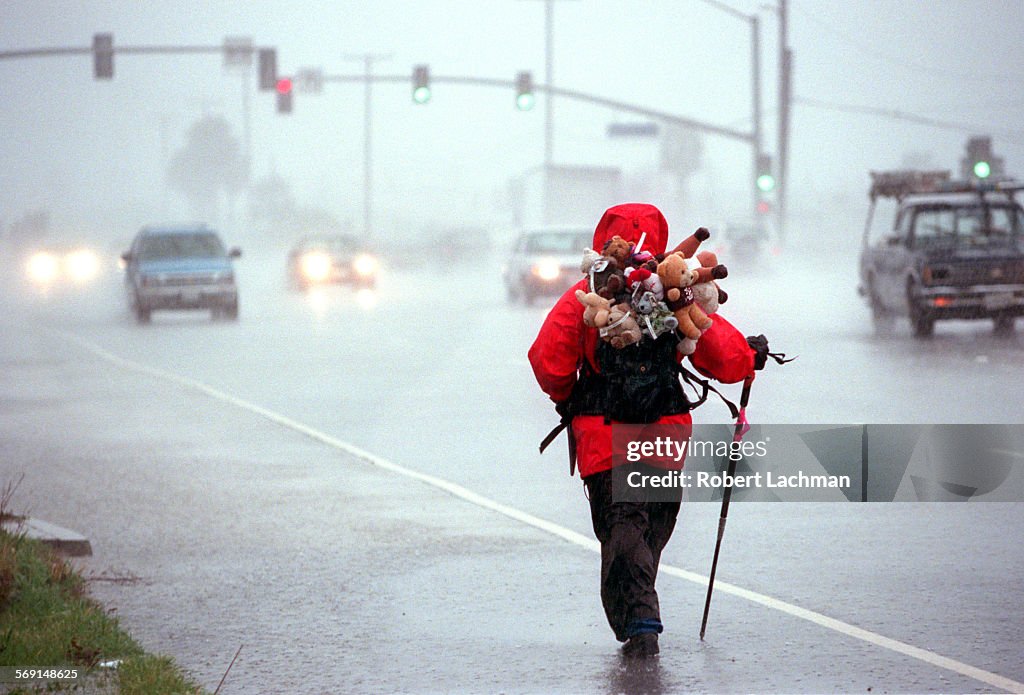 ME.Walker.Rain.RDL (kodak) (2/6/98) (Huntington Beach, CA) Louie Rochon strolls in the pouring rain 