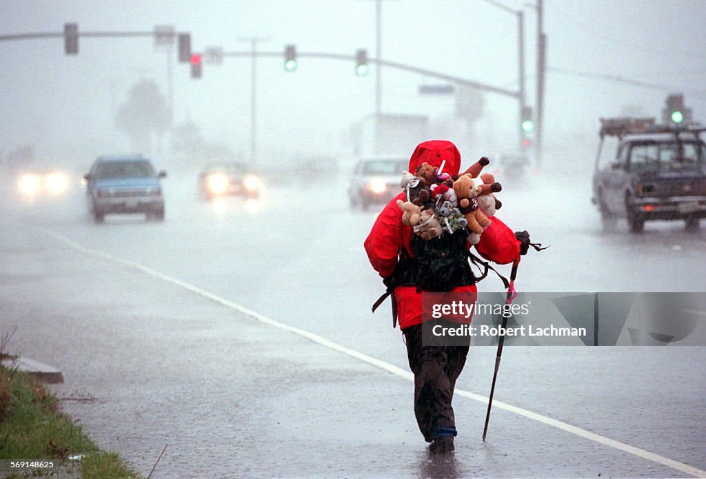 ME.Walker.Rain.RDL (kodak) (2/6/98) (Huntington Beach, CA) Louie Rochon strolls in the pouring rain