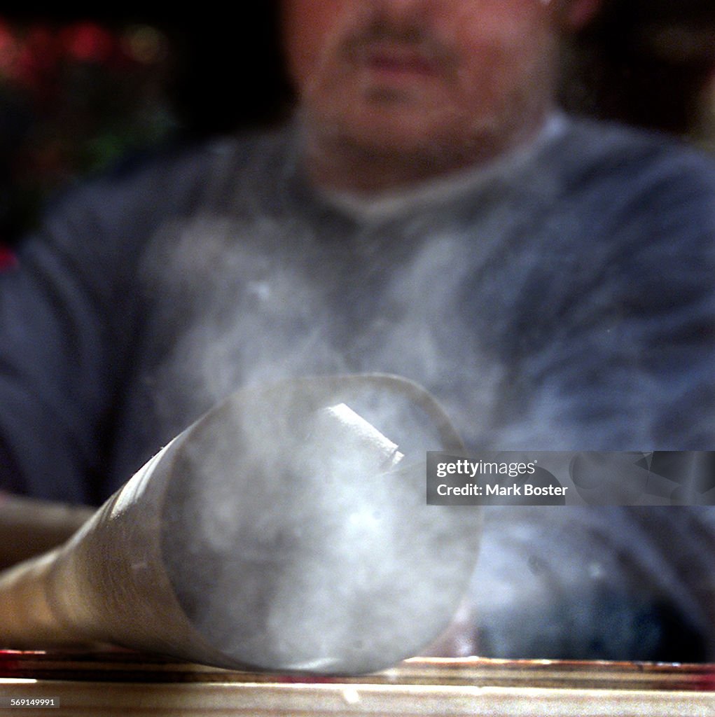 Joseph McStay uses an air compressor to blow out dust from the pipes of the vintage pipe organ in th