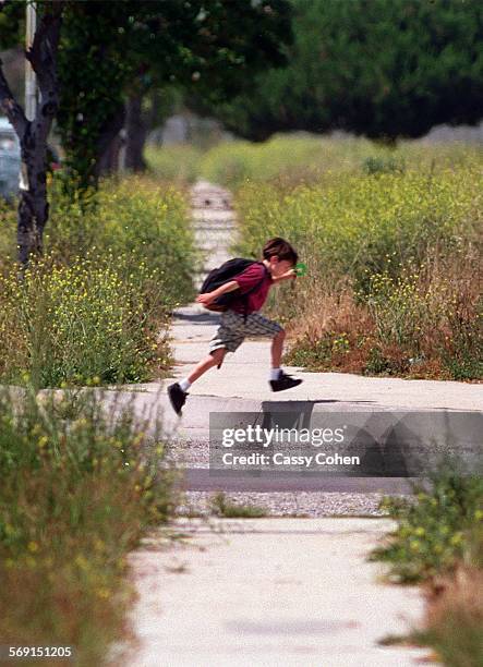 Youngster scampers home after school has let out in the Holly Glen area of Hawthorne. Boy runs east on 135th Street near Glasgow Avenue.