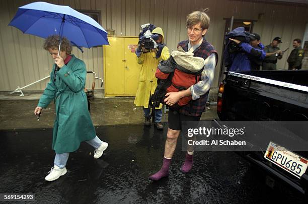 Lost hiker Bill Cunningham, right of Mission Viejo, leaves the Modjeska Canyon fire station in his socks, carrying his backpack with his wife, Laura,...