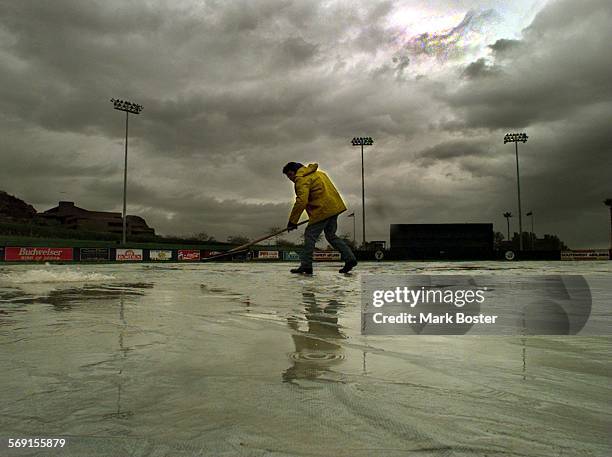 Rainout.022797.MBGround crews at Tempe Diablo Stadium went scrambling with their squeegees thursday afternoon when a rainstorm swept through the...