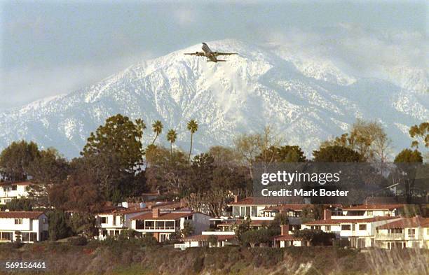Jetliner lifting off from John Wayne Airport is dwarfed by the snow capped peaks of Mount Baldy tuesday afternoon photographed from the Upper Newport...