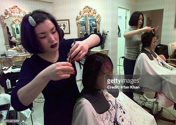 KoreaTown.5.0701.IK ; Buena Park, July 01 Jackie Kim ,left. Cuts Michelle Kwon's hair at a hair salon located inside Super One Mart which caters to...