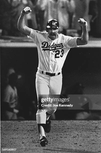 Kirk Gibson of the Los Angeles Dodgers raises his arms in celebration as he rounds the bases after hitting the game winning two run homer in the...