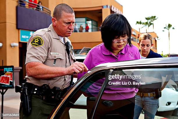 Dr. HsiuYing "Lisa" Tseng is escorted out of her Rowland Heights clinic on March 1 by law enforcement officials.