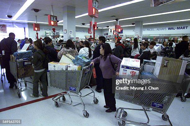PostThanksgiving shoppers at the Panorama City Mall WalMart on Friday morning do their holiday shopping with some pulling along two carts. DIGITAL...