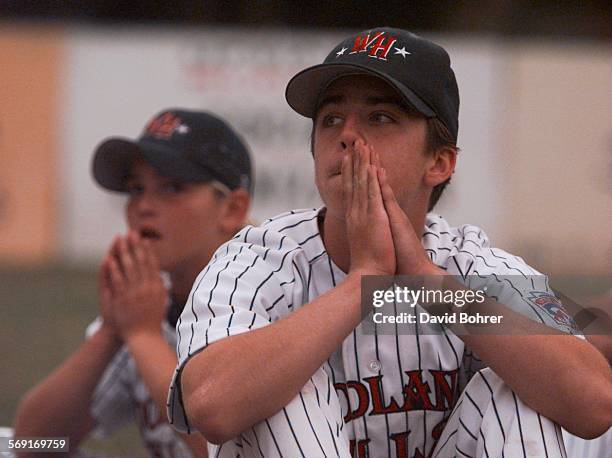 Woodland Hills players Ryan Malleus and pitcher Jimmy Roberts hold back tears as they watch the celebrations put on by their opponent Thousand Oaks....