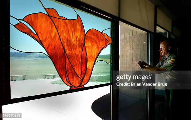 State park maintenance supervisor Bill Verdery cleans specially insulated glass at the Antelope Valley Poppy Reserve visitor center. The center's...