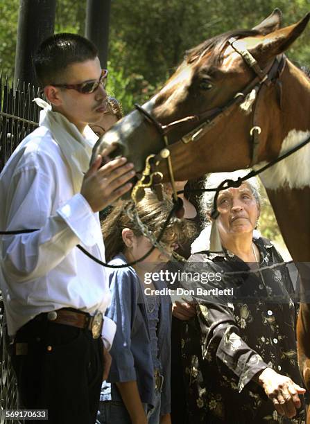 Salvador Uribe Jr and his grandmother Paula Estrada stand with his late father's horse after graveside services at Rancho Mission Viejo. His father,...