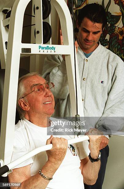 McMahon.1.0224.RM.8 Ed McMahon works out at home with the help of trainer Jon Jon Park . McMahon is using a weight machine. McMahoon and his wife Pam...