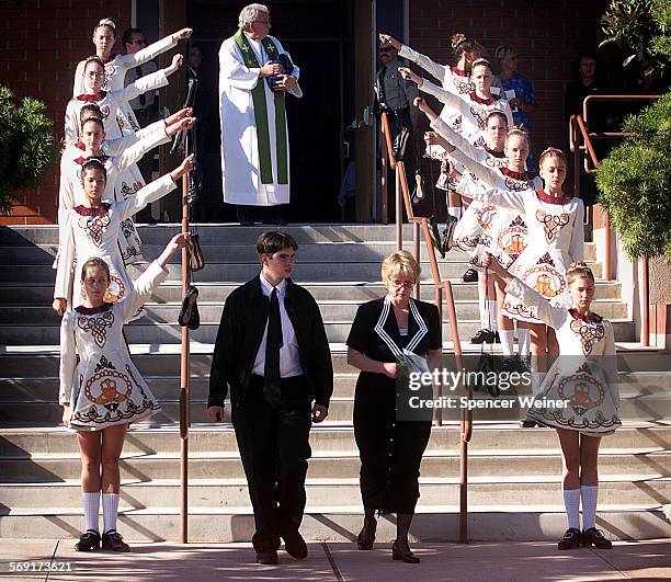 Remains of Megan Barroso are cradled in arms of Rev. Gerald Garrett as Suzan Barroso , mother of Megan Barroso, walks past CLaddagh dance troupe...