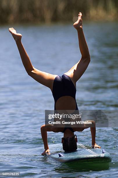 Nicole Worden a member of the Junior Lifeguard program at Castaic Lake, tries to do a headstand on a paddle board. It was a good day to be on the...