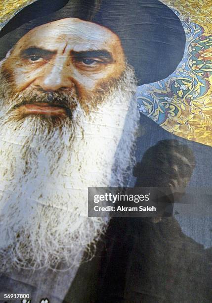 An Iraqi Shiite man carries a picture of Iraq's powerful Shiite cleric Grand Ayatollah Ali al-Sistani as he takes part in a protest against the...