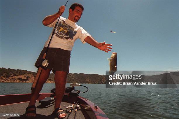 Bass.2.bv.514/CASTAIC  A bass fisherman Robert Cohn of Van Nuys pulls in a small bass from the waters of Castaic Lake Wednesday May 7 1997.