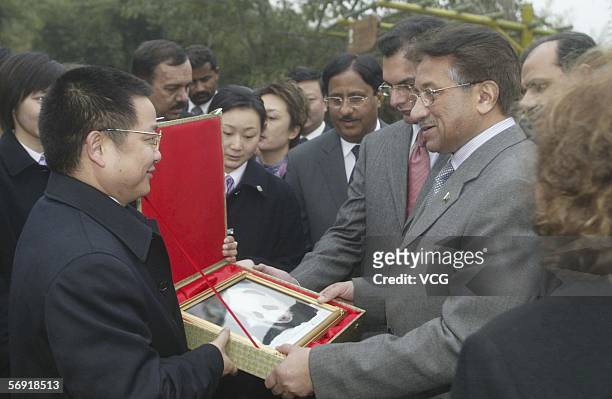 Pakistani President Pervez Musharraf receives a present at Chengdu giant panda breeding center on February 23 in Chengdu, Sichuan province, China....