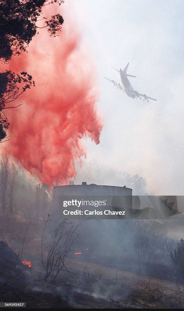 Airtanker drops retardent over a hot area on a hillside during a bursh fire in Somis.