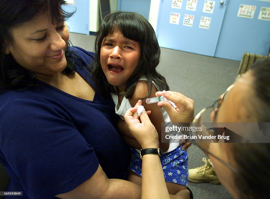 Laura Lopez holds her sixyearold daughter Julie Marquez(CQ) as feels the needle from a Hepatitis A