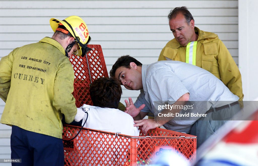 Firefighters tend to a customer (seated in the shopping cart) in the aftermath of an apparent attemp