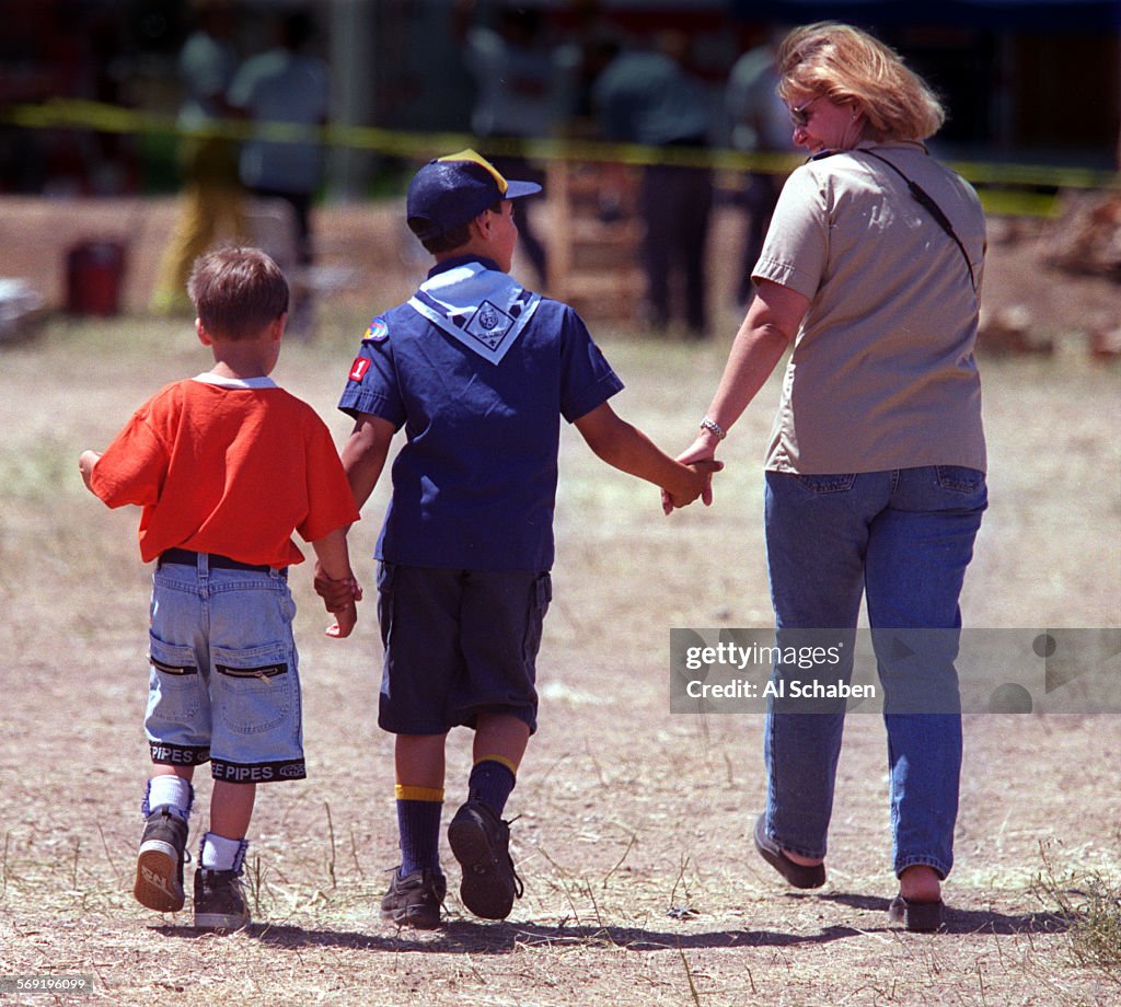 Linda Adintori, of Laguna Niguel, holds the hand of her son, Evan Adintori, 9, of Cub Scout Pack 771