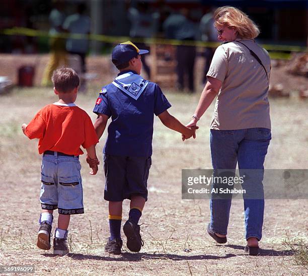 Linda Adintori, of Laguna Niguel, holds the hand of her son, Evan Adintori of Cub Scout Pack 771 of Laguna Niguel, and his friend, Stephen Lane left,...