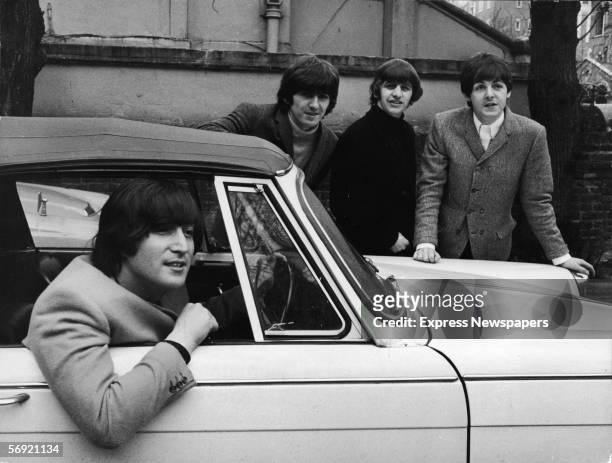 John Lennon , of the British pop group the Beatles, sits in his car after passing his driving test, February 16, 1965. Bandmates, from left, George...