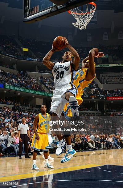 Dahntay Jones of the Memphis Grizzlies shoots against Desmond Mason of the New Orleans/Oklahoma City Hornets on January 28, 2006 at the FedExForum in...