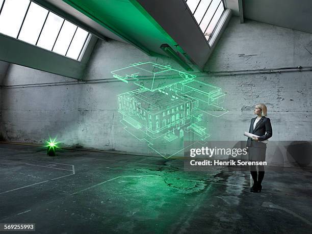 female architect looking at a holographic house - hologramm stock-fotos und bilder