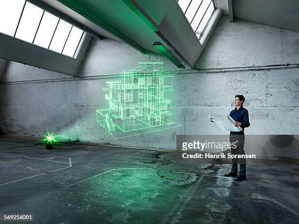 male architect looking at a holographic house - hologram projection stock pictures, royalty-free photos & images