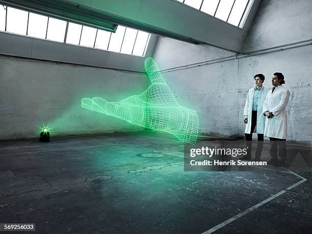 scientists looking at a holographic hand - scientist standing stock-fotos und bilder