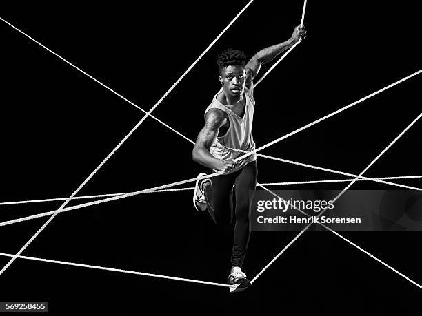 male athlete running on ropes - male athlete with rope on black background stock pictures, royalty-free photos & images