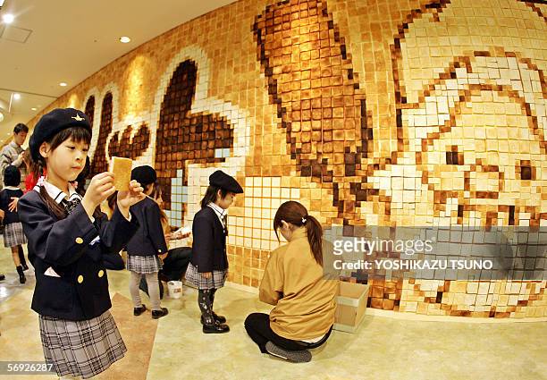 Kindergarten children put the final touches on an art work made of toasted bread at a bread theme park in Funabashi, suburban Tokyo, 24 February...