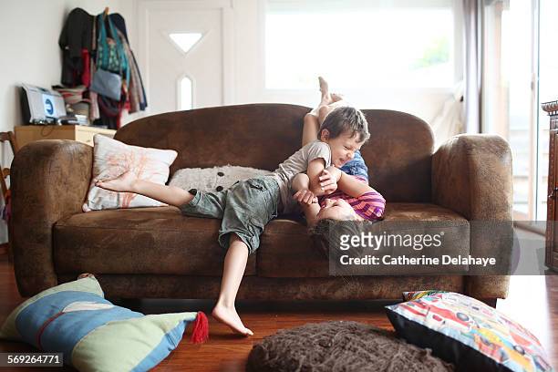 2 children playing together on a sofa