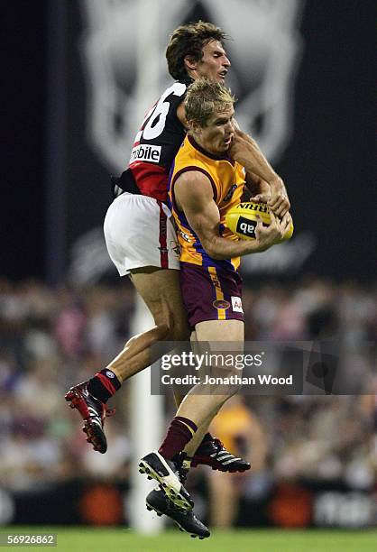 Troy Selwood of the Lions takes the mark ahead of Richard Cole of Essendon during the first round NAB Cup match between the Brisbane Lions and...