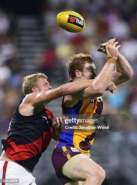 Daniel Merrett of the Lions contests the ball with Dustin Fletcher of Essendon during the first round NAB Cup match between the Brisbane Lions and...