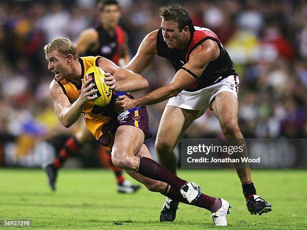 Michael Voss of the Lions is tackled during the first round NAB Cup match between the Brisbane Lions and Essendon at Carrara Stadium on February 24,...