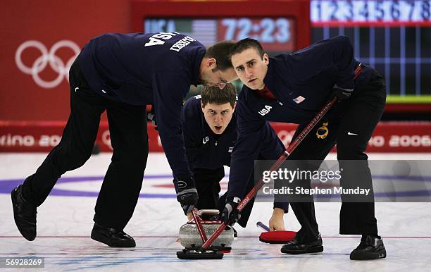 John Shuster of United States releases the stone as Shawn Rojeski and Joe Polo of United States brush the ice during the Gold medal match of the...