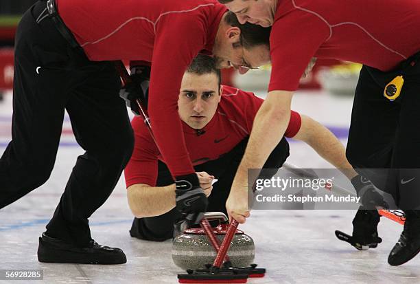 Joe Polo of United States releases a stone as Shawn Rojeski and John Shuster of United States brush the ice during the Gold medal match of the men's...