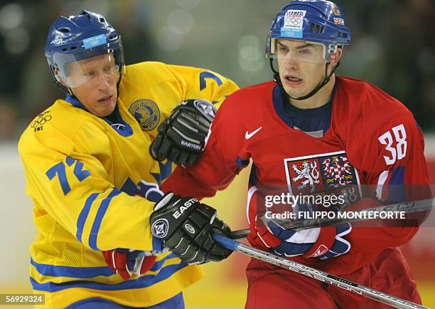 Swedish Jorgen Jonsson vies with Czech Jan Bulis during the 2006 Winter Olympic ice hockey men's semi-final game between Sweden and Czech Republic,...